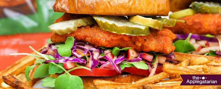 Fries in front of a Chicken Sandwich and product packaging