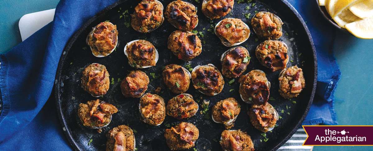 Black plate with a spread of clams casino on top. 