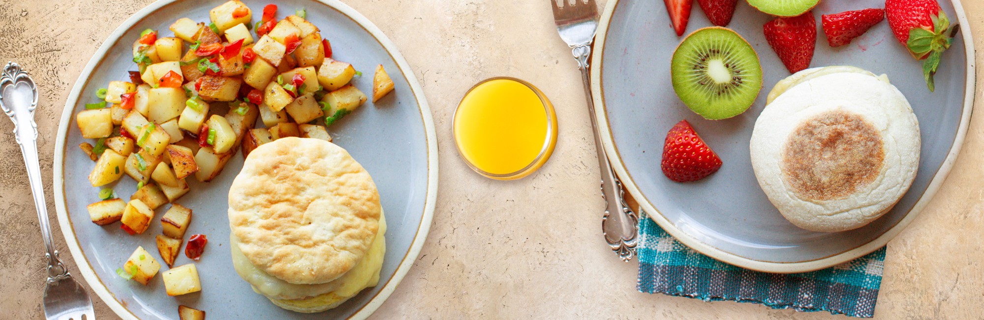 Breakfast, HANDLED. A spread of various breakfast foods including English muffin and Biscuit breakfast sandwhich
